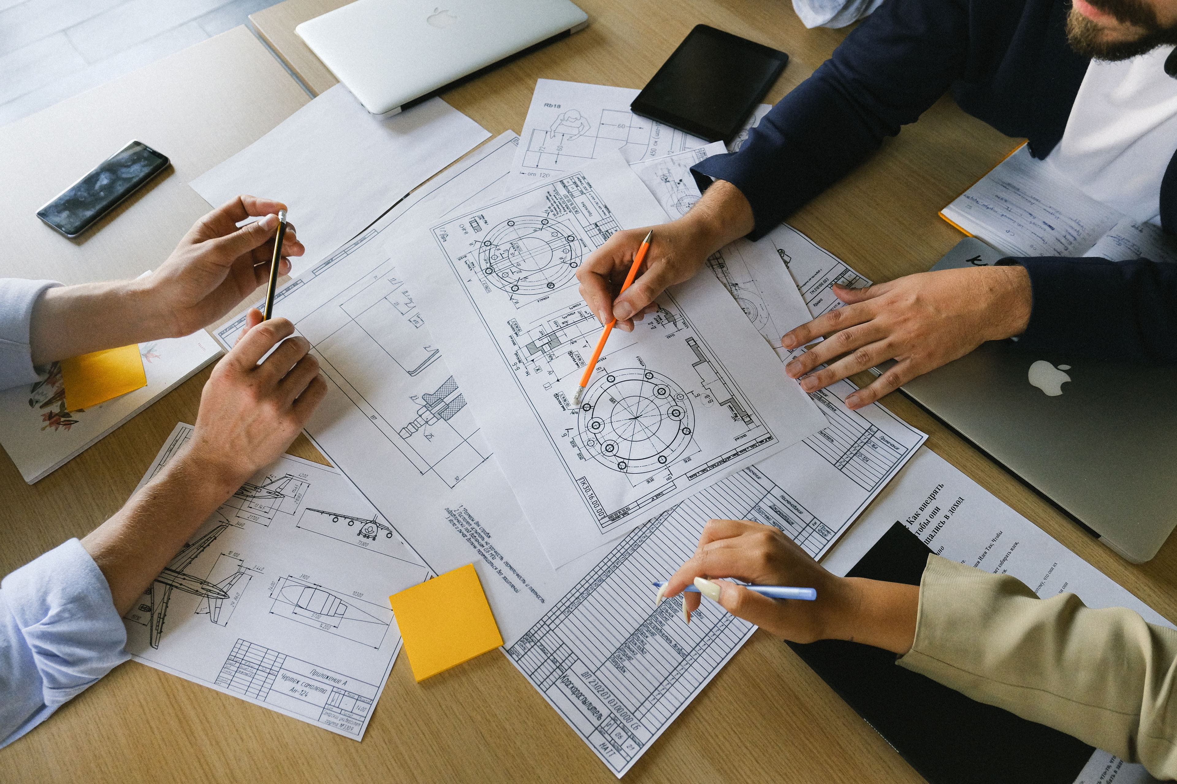Engineering team reviewing technical drawings during a project planning discussion